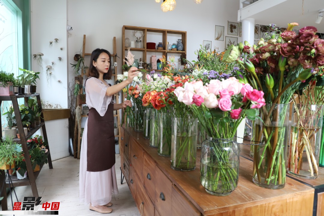 王黎媛是一名河南姑娘，在昆明念完大學(xué)后，就再也舍不下春城的藍(lán)天陽(yáng)光、青山碧水，更舍不下這里的四時(shí)繁花，于是就干脆留了下來(lái)，成了一名媒體人。2017年的時(shí)候又毅然辭去工作，創(chuàng)業(yè)開(kāi)起了花店，成了都市里的一名“花房姑娘”。圖為王黎媛在自己的花店中整理鮮花。新華網(wǎng) 周亞平/攝 念新洪/文