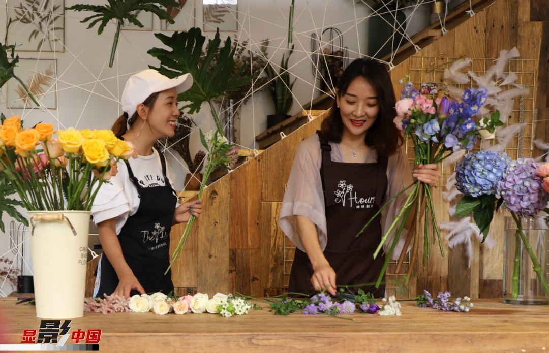 “昆明是鮮花的原產地，有亞洲最大的鮮切花交易市場，可以說具備開花店的天時地利；另外和很多女孩一樣，我從小也就有開花店的夢想！”說起當初的決定，王黎媛說一是因為夢想，另外也跟昆明這個城市產花、賣花的“基因”有關。圖為王黎媛和同事在制作花束。新華網 周亞平/攝 念新洪/文